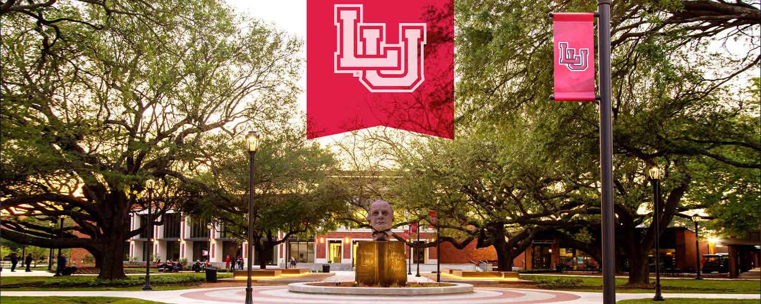 Lamar University campus featuring a statue and banners with the LU logo, symbolizing the university's commitment to excellence and innovation in education and event experiences.